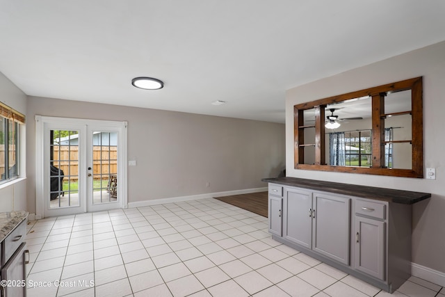 spare room with french doors, light tile patterned flooring, and baseboards