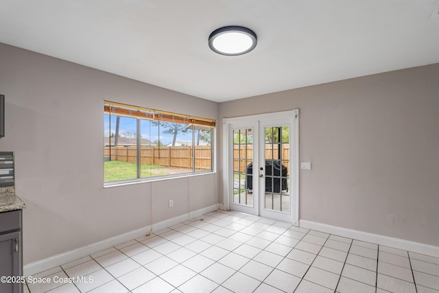 unfurnished room with light tile patterned floors, french doors, baseboards, and a healthy amount of sunlight