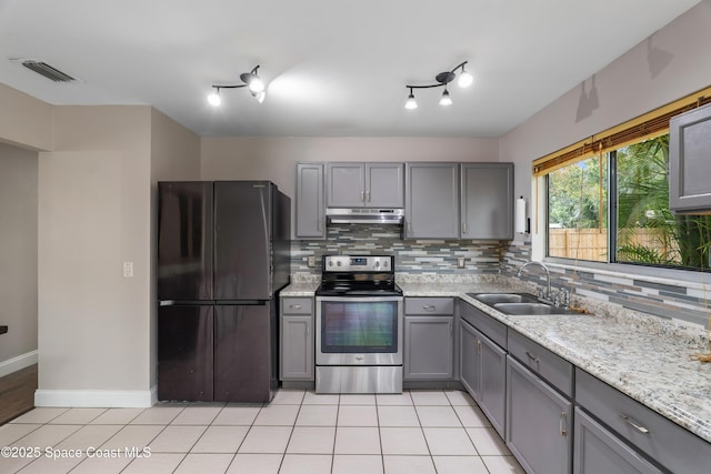 kitchen with visible vents, freestanding refrigerator, under cabinet range hood, stainless steel range with electric stovetop, and a sink