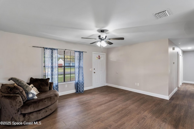 living room with a ceiling fan, dark wood-style flooring, visible vents, and baseboards