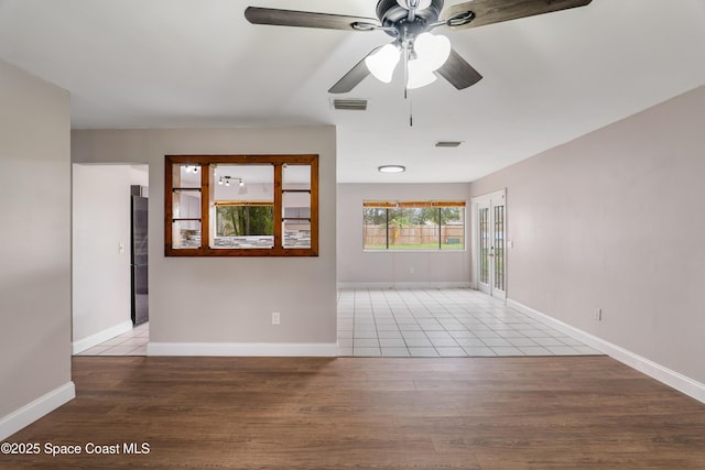 unfurnished room featuring light wood-type flooring, visible vents, and baseboards