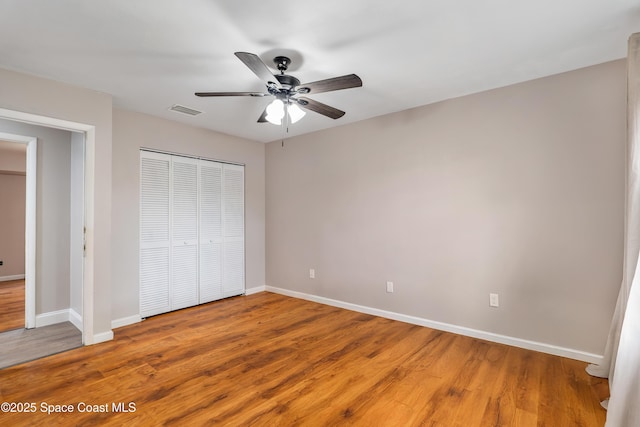 unfurnished bedroom with a closet, baseboards, and wood finished floors