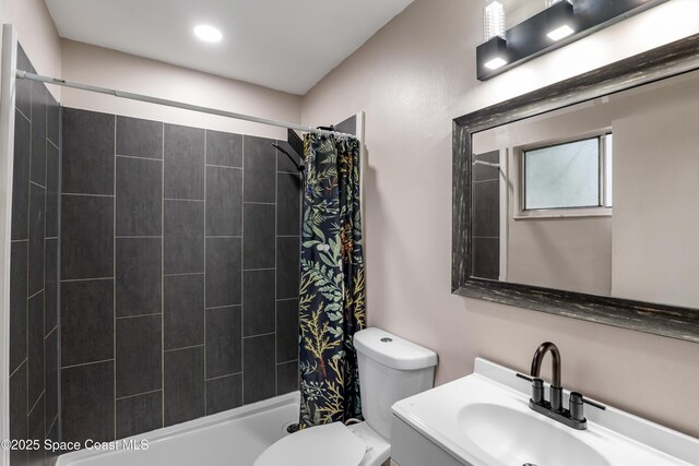 bathroom with a stall shower, vanity, and toilet