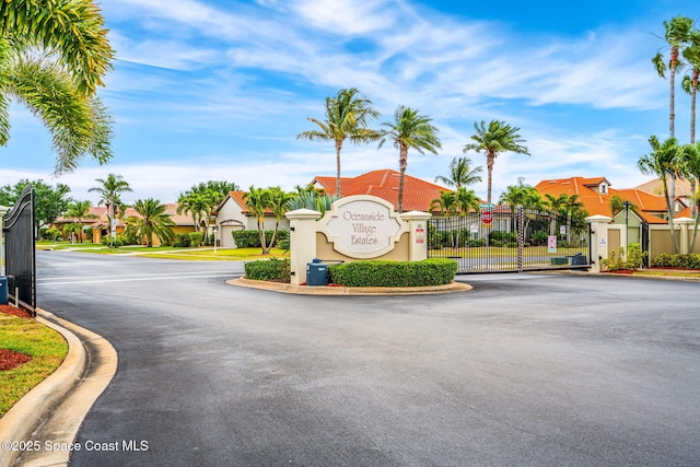 view of road featuring curbs, a gated entry, a residential view, and a gate