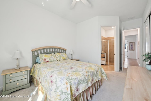 bedroom featuring light carpet, ensuite bath, and a ceiling fan