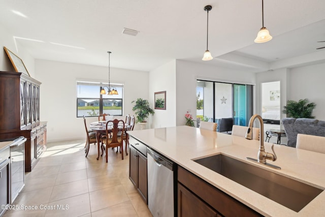 kitchen with light tile patterned floors, visible vents, dishwasher, pendant lighting, and a sink