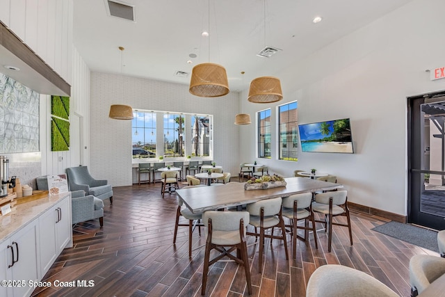 dining area featuring wood finish floors, visible vents, and baseboards