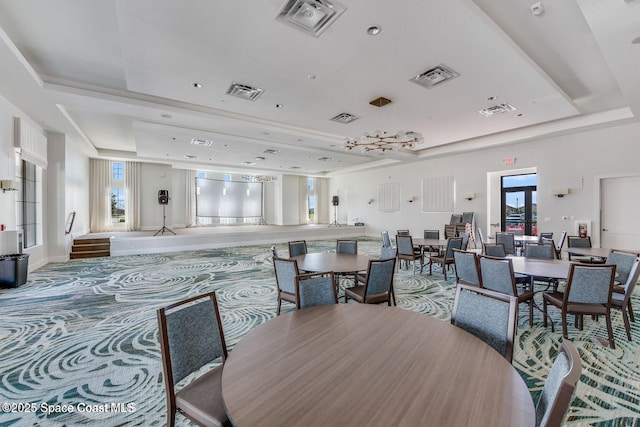 dining room with a raised ceiling and visible vents