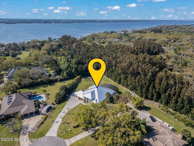 birds eye view of property with a water view and a forest view