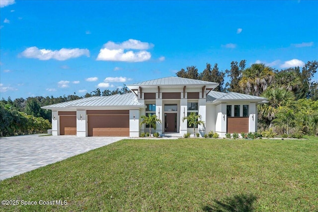 modern home featuring a garage, a standing seam roof, and a front yard