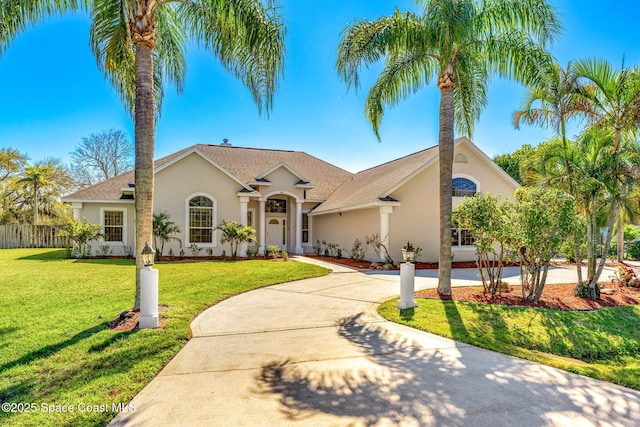 mediterranean / spanish home with driveway, a front lawn, and stucco siding