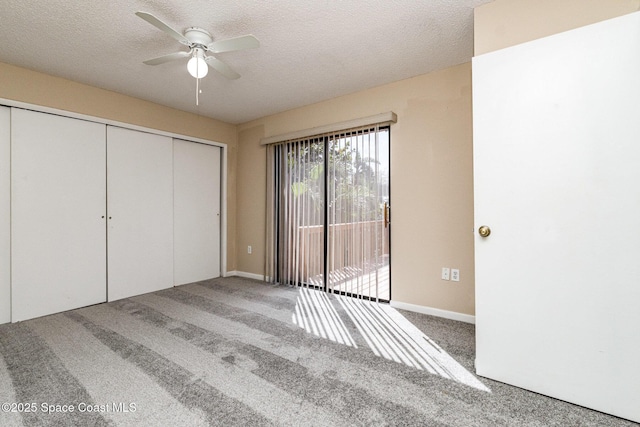 unfurnished bedroom with a closet, access to exterior, carpet flooring, a ceiling fan, and a textured ceiling