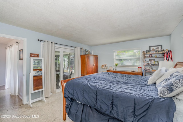 bedroom with access to exterior and a textured ceiling