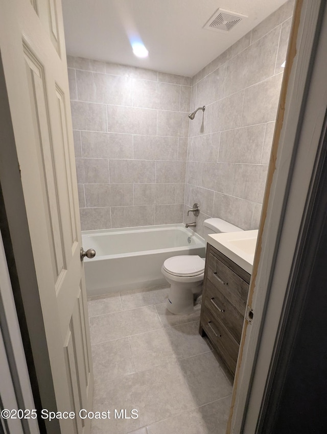 full bathroom featuring tiled shower / bath combo, toilet, tile patterned flooring, and vanity