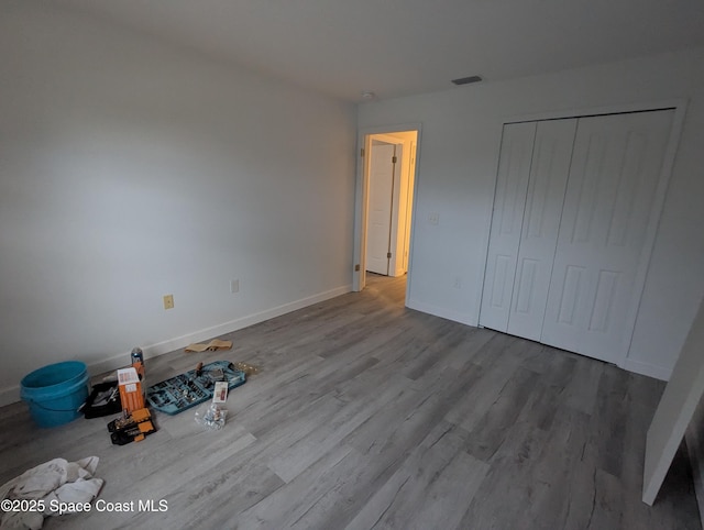 unfurnished bedroom featuring a closet and hardwood / wood-style floors