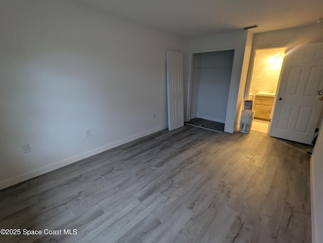 unfurnished bedroom with a closet and hardwood / wood-style floors