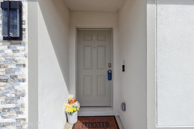 property entrance with stucco siding