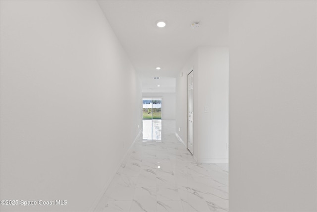 corridor featuring marble finish floor, baseboards, and recessed lighting