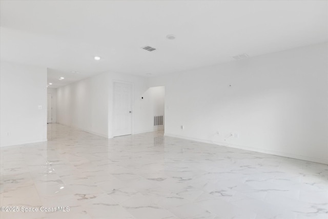 empty room featuring marble finish floor, visible vents, and baseboards