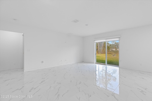 spare room with marble finish floor and baseboards