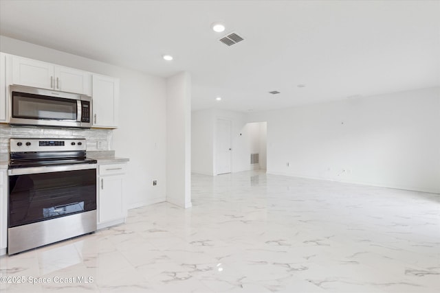 kitchen featuring decorative backsplash, appliances with stainless steel finishes, open floor plan, marble finish floor, and white cabinetry