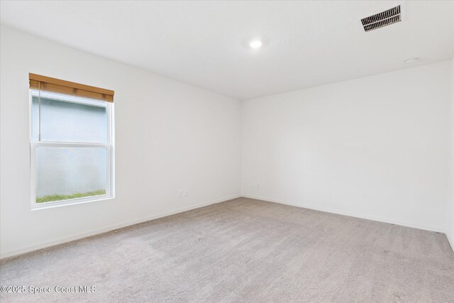 carpeted empty room featuring visible vents