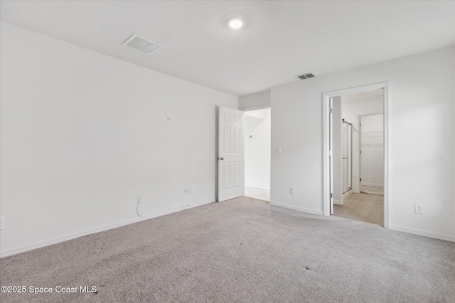 unfurnished bedroom with carpet, visible vents, and baseboards