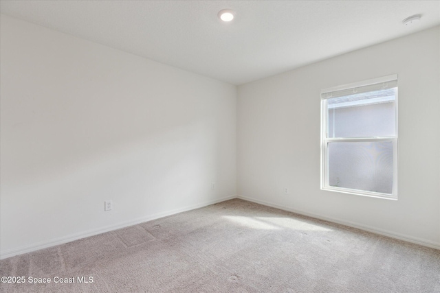 spare room with carpet and baseboards