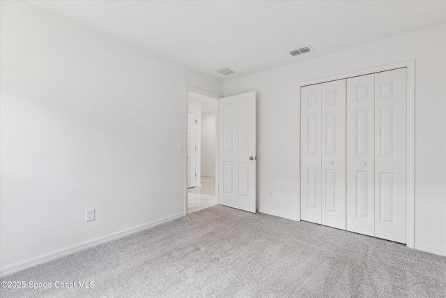 unfurnished bedroom featuring a closet, carpet, visible vents, and baseboards