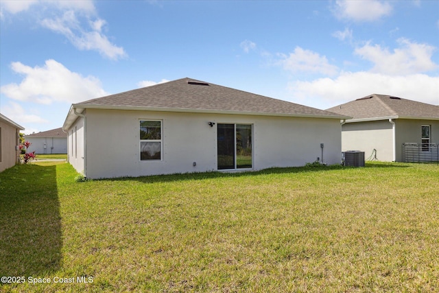 back of property featuring a yard, a shingled roof, cooling unit, and stucco siding