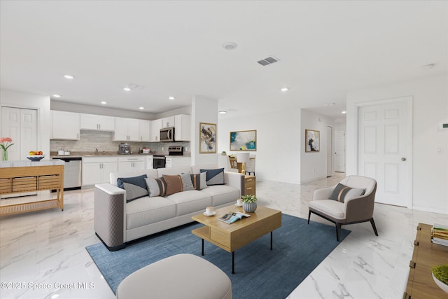 living area featuring marble finish floor, visible vents, and recessed lighting