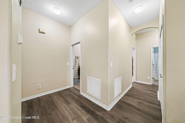 hallway with dark hardwood / wood-style floors and a textured ceiling