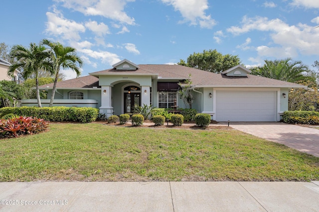 ranch-style house featuring a front lawn, decorative driveway, an attached garage, and stucco siding