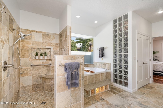 ensuite bathroom with connected bathroom, a tile shower, a textured ceiling, a bath, and recessed lighting