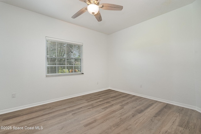 spare room with ceiling fan, baseboards, and wood finished floors