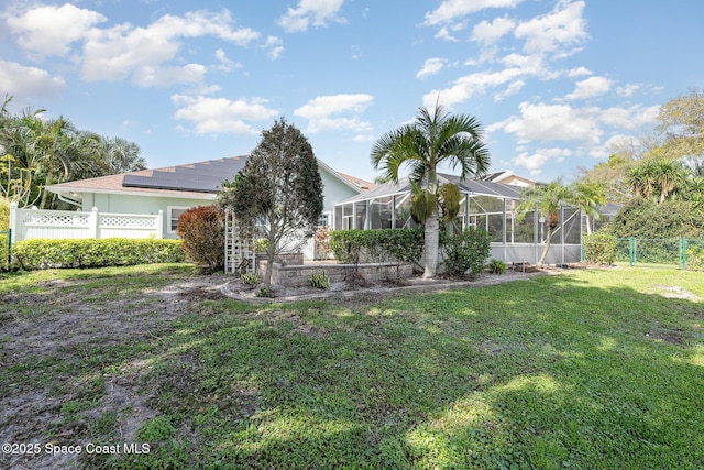 view of property hidden behind natural elements featuring a front yard, a lanai, and fence private yard