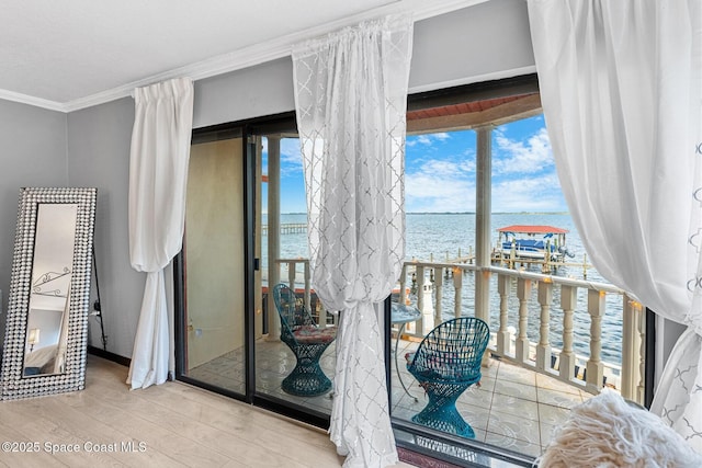 interior space featuring ornamental molding, a water view, and wood finished floors