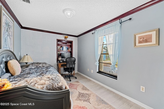 bedroom with light wood-type flooring, a textured ceiling, baseboards, and crown molding