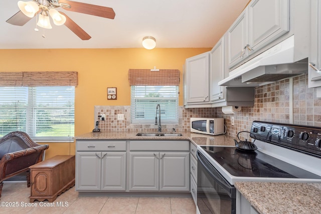 kitchen with white microwave, under cabinet range hood, black range with electric stovetop, a sink, and white cabinetry