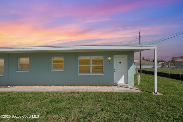 view of front of home with a front yard and concrete block siding