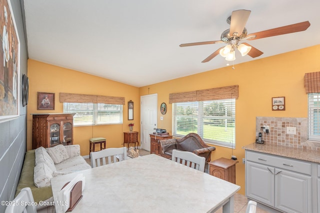 dining room featuring a healthy amount of sunlight, vaulted ceiling, and a ceiling fan