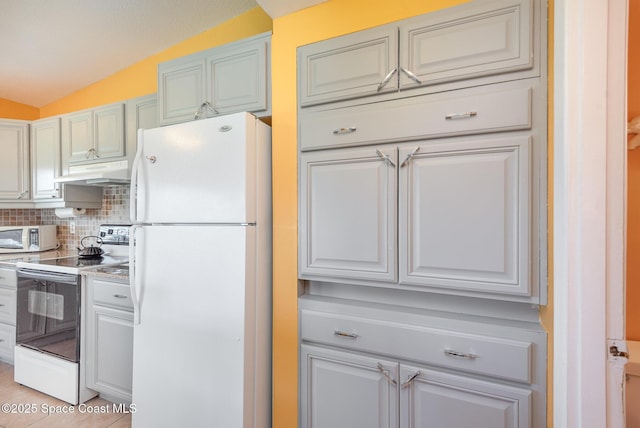 kitchen with white appliances, tasteful backsplash, lofted ceiling, light countertops, and under cabinet range hood