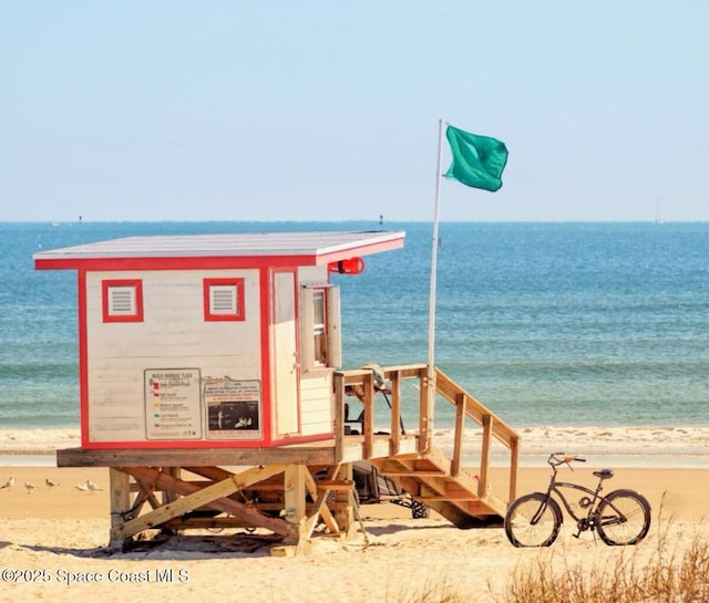 exterior space featuring a water view and a beach view