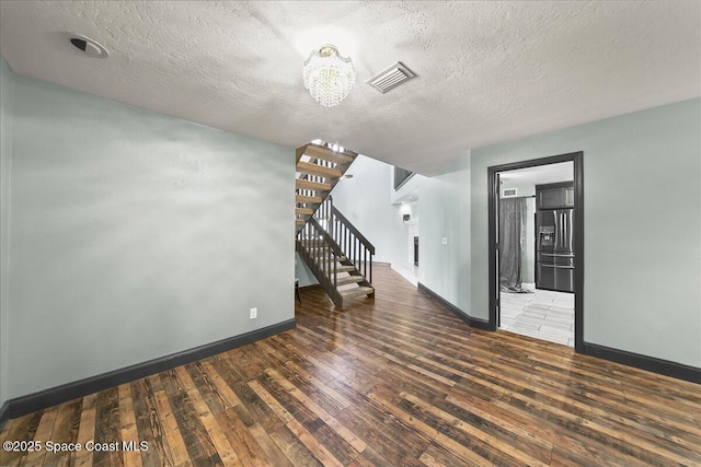 unfurnished room with baseboards, stairs, visible vents, and dark wood-type flooring