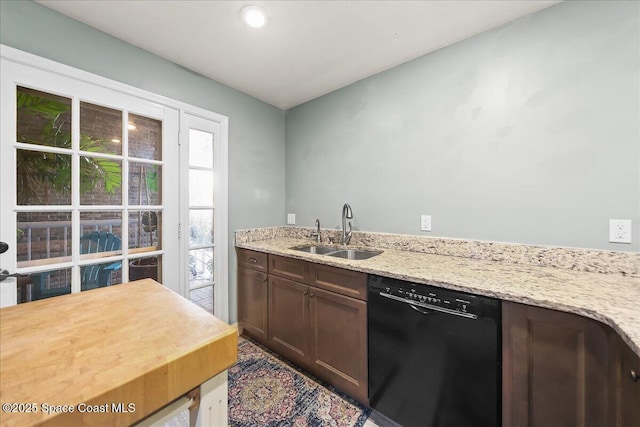 kitchen featuring dark brown cabinetry, dishwasher, a sink, and light stone countertops