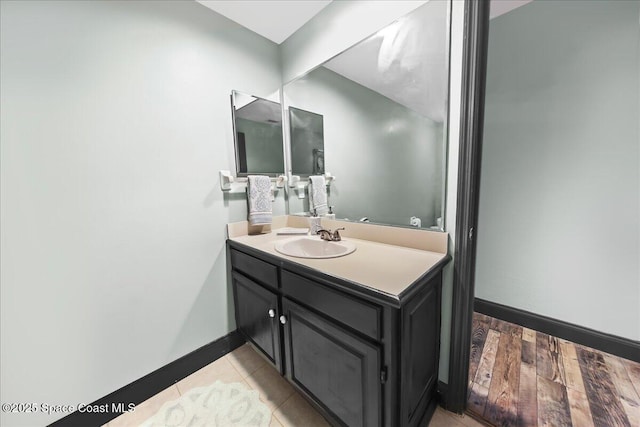 bathroom with vanity, baseboards, and wood finished floors