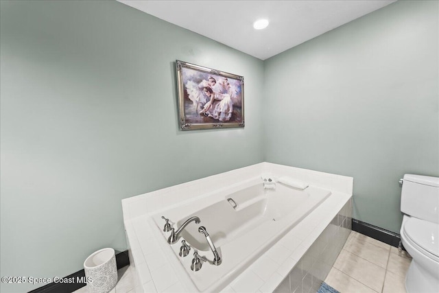 bathroom featuring a bath, baseboards, toilet, and tile patterned floors