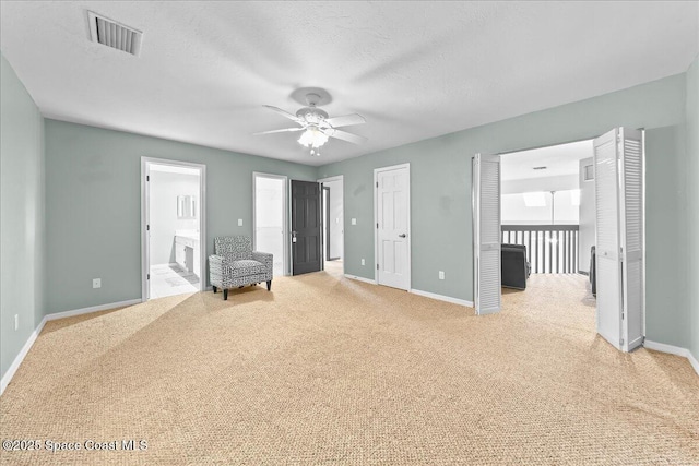 unfurnished room featuring light carpet, baseboards, visible vents, ceiling fan, and a textured ceiling