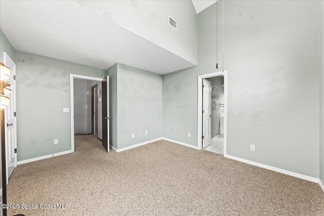 interior space featuring baseboards, visible vents, and light colored carpet