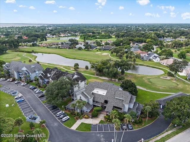 drone / aerial view featuring view of golf course, a water view, and a residential view